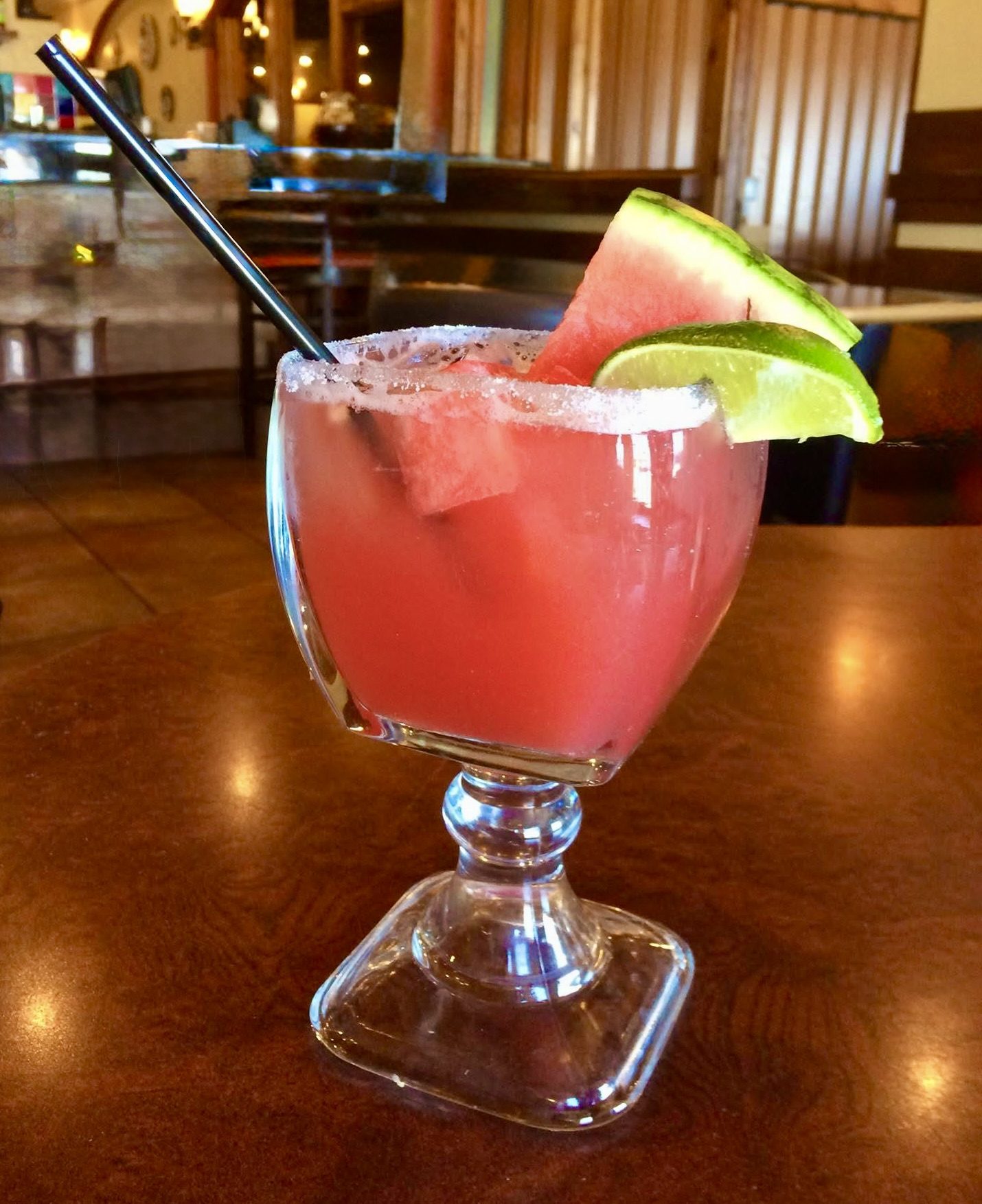 Fresh watermelon margarita with salt rim, lime wedge, and watermelon garnish on a Los Cabos bar top